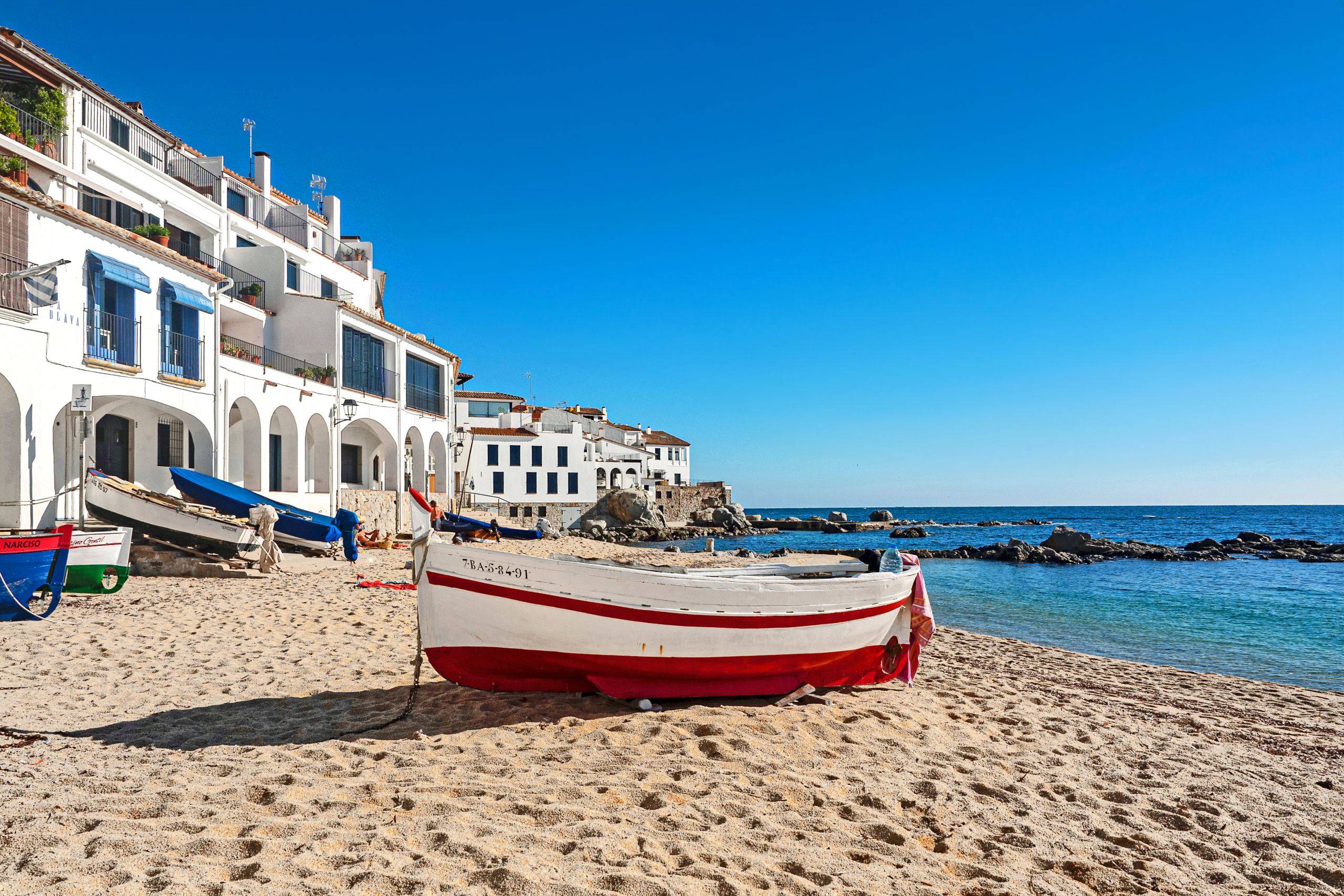 Spiaggia con barche tradizionali a Cadaqués, un pittoresco villaggio della Costa Brava, Spagna.