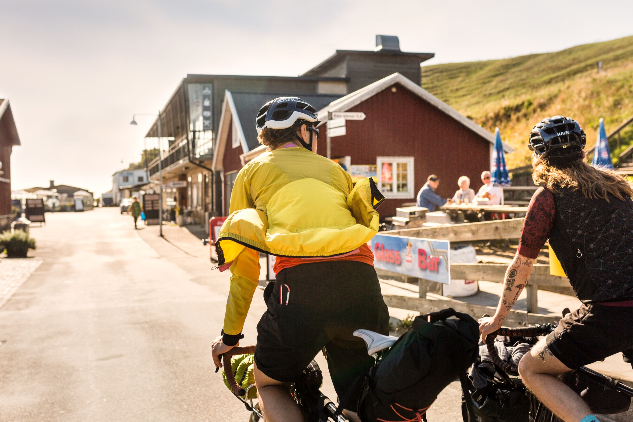 Gruppo di ciclisti in pausa davanti a una tradizionale casetta rossa lungo la costa sud della Svezia.