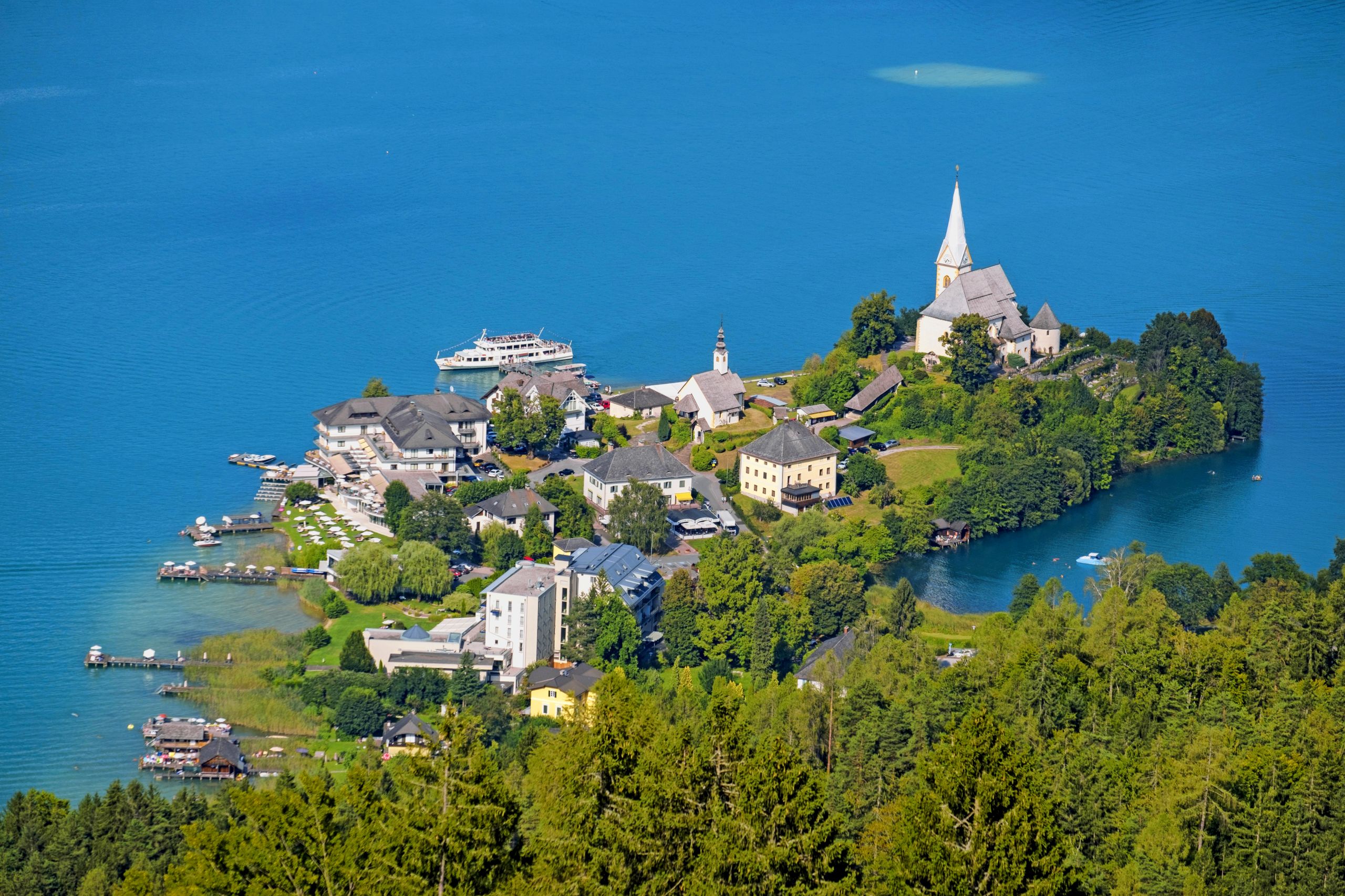 Veduta aerea di un castello e di un lago nella regione di Villach, Carinzia.