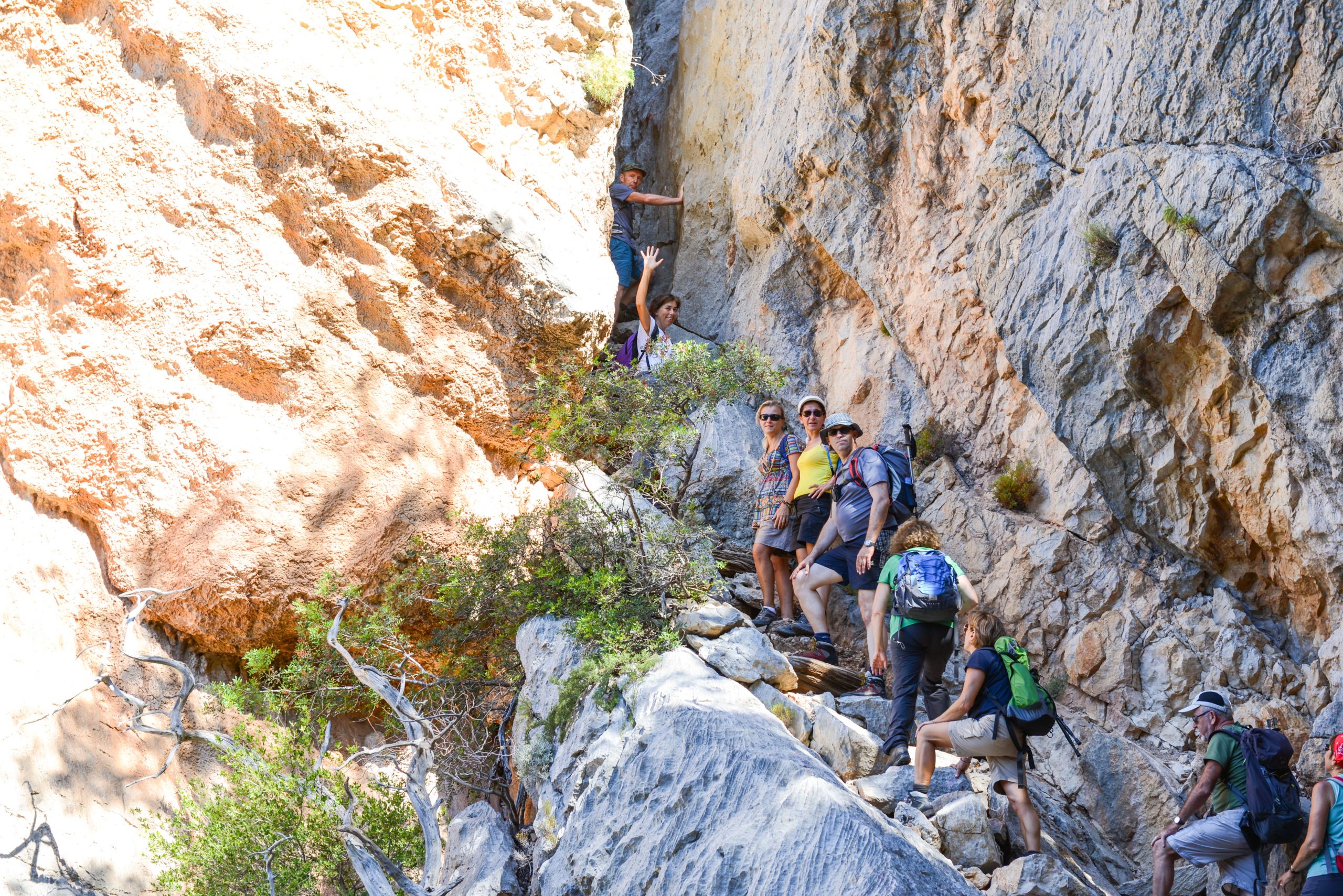 Gruppo di escursionisti, passaggio stretto, paesaggio roccioso tra cala Gonone e Golfo di Orosei, Sardegna