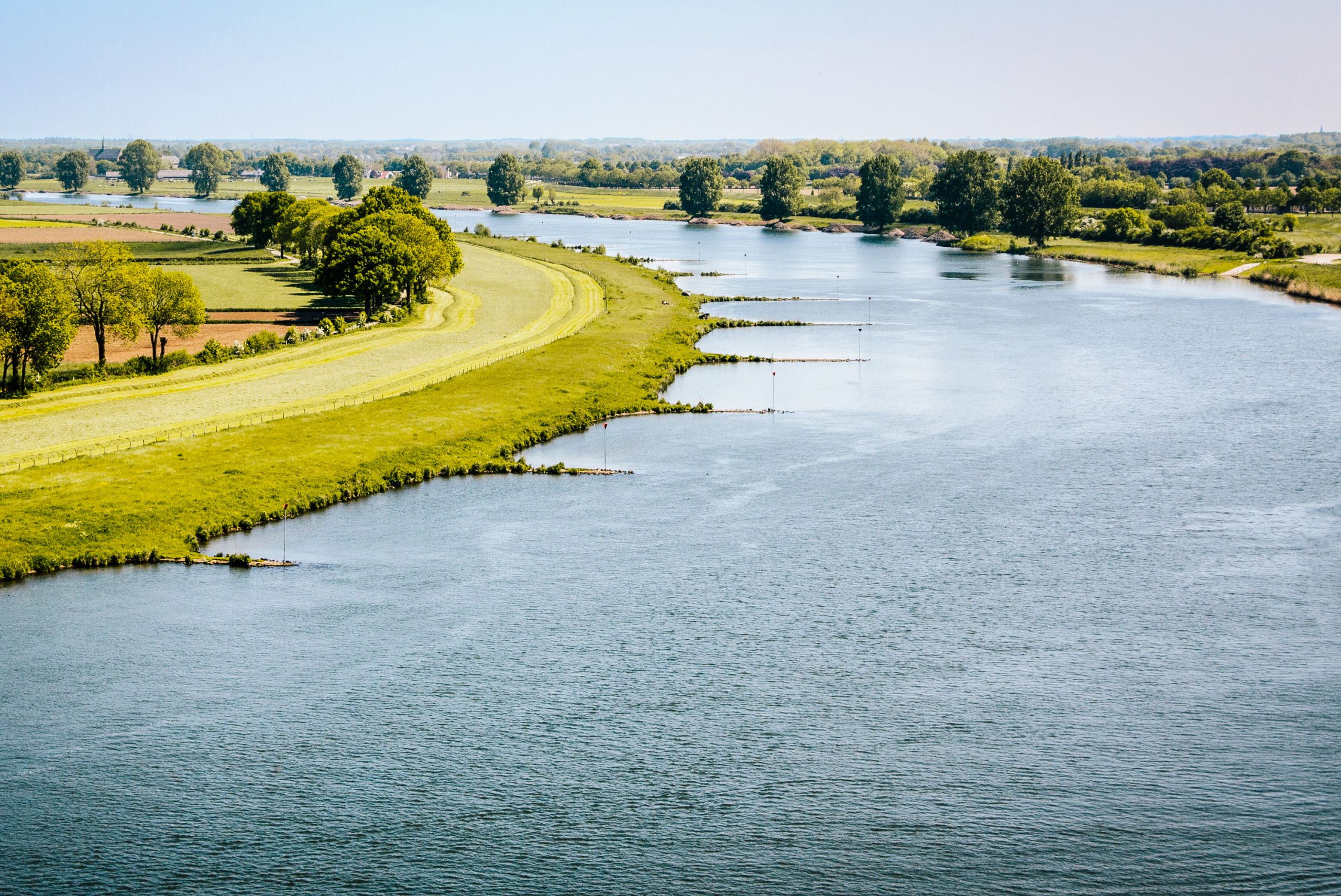 Der Fluss Waal fließt zwischen grünen Landschaften in den Niederlanden.
