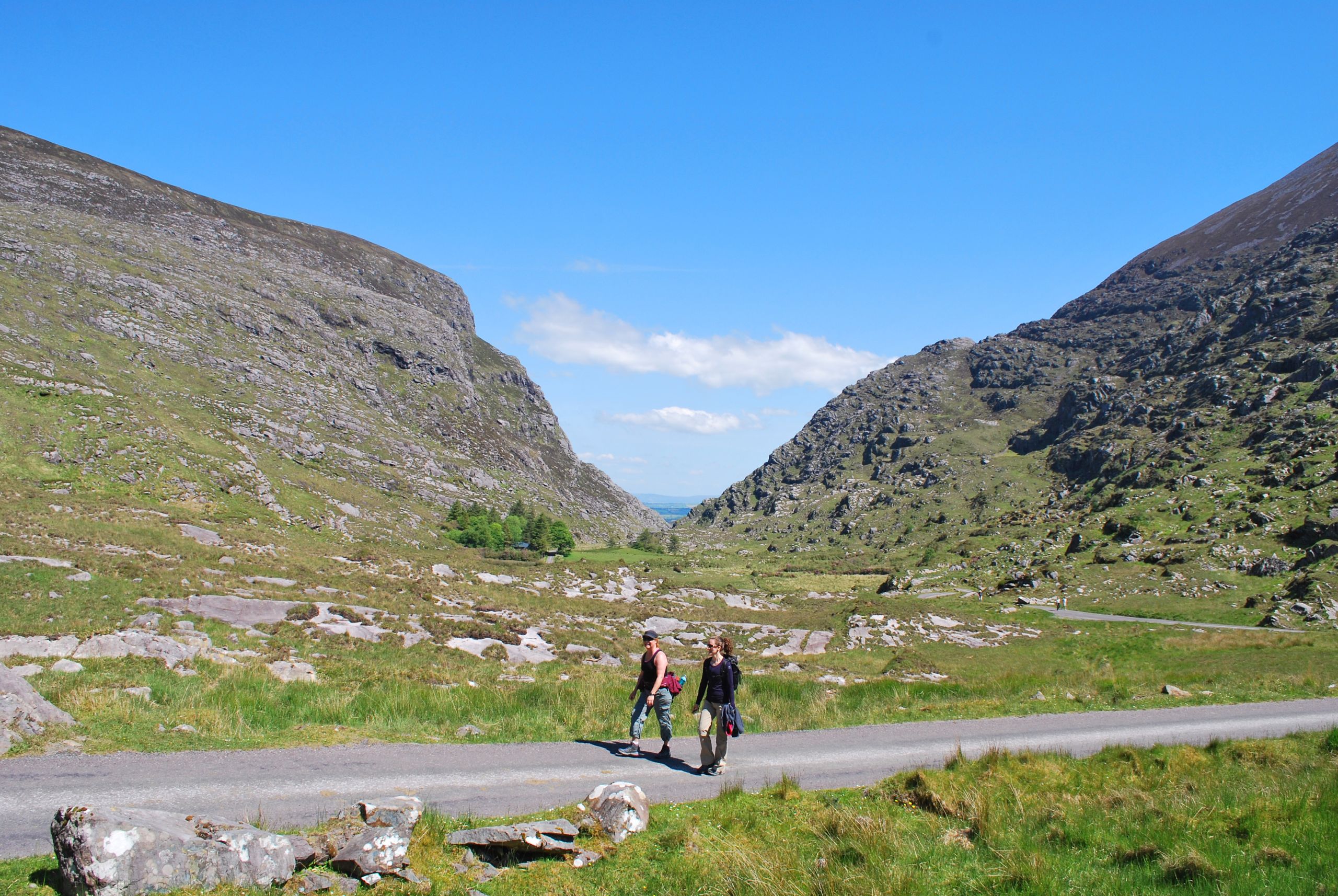Camminatori su sentiero di montagna con pascoli e colline nel Kerry.