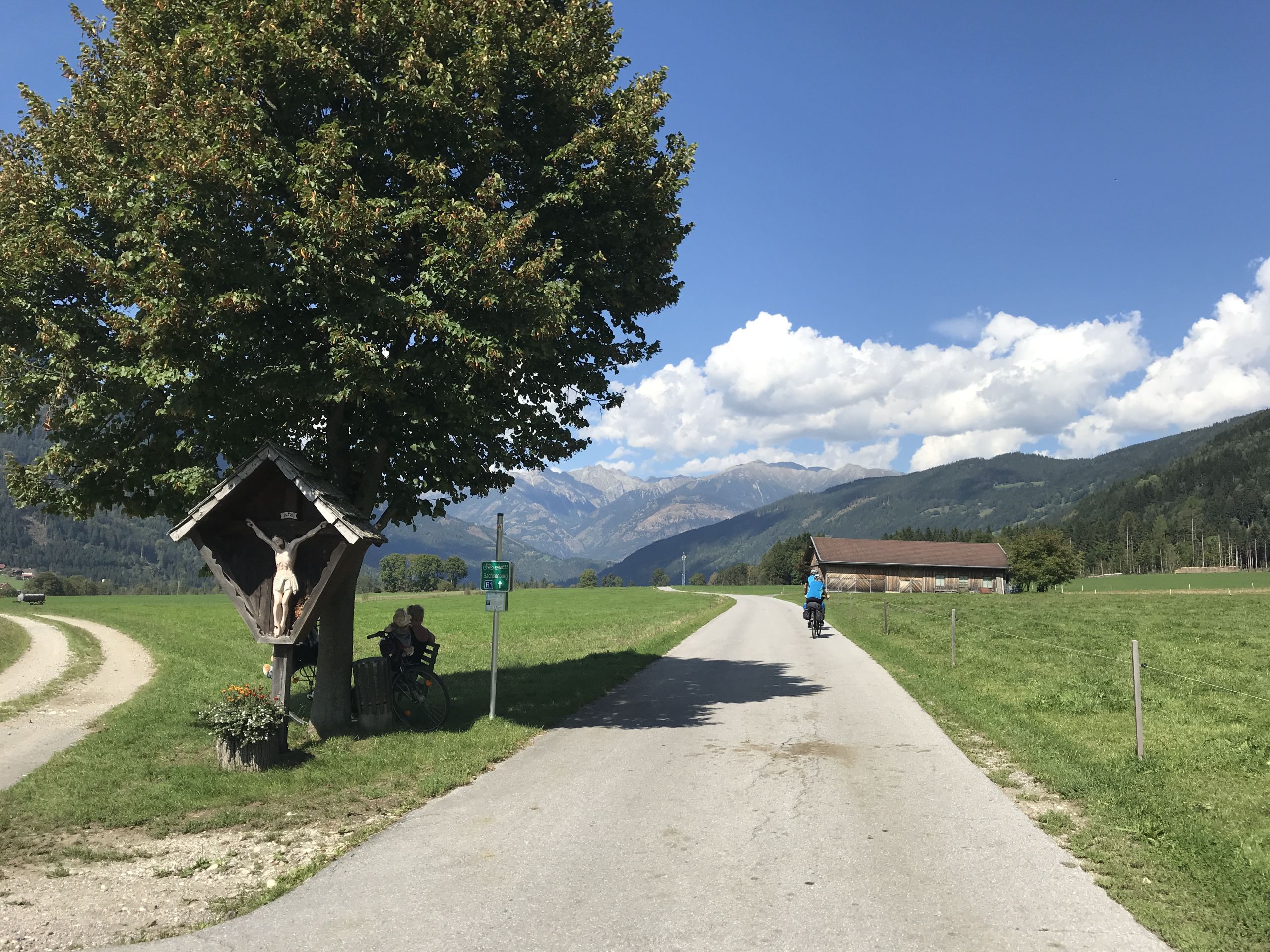 cicloturista, paesaggio verde pianeggiante, sfondo collinare, ciclabile della Drava in Austria