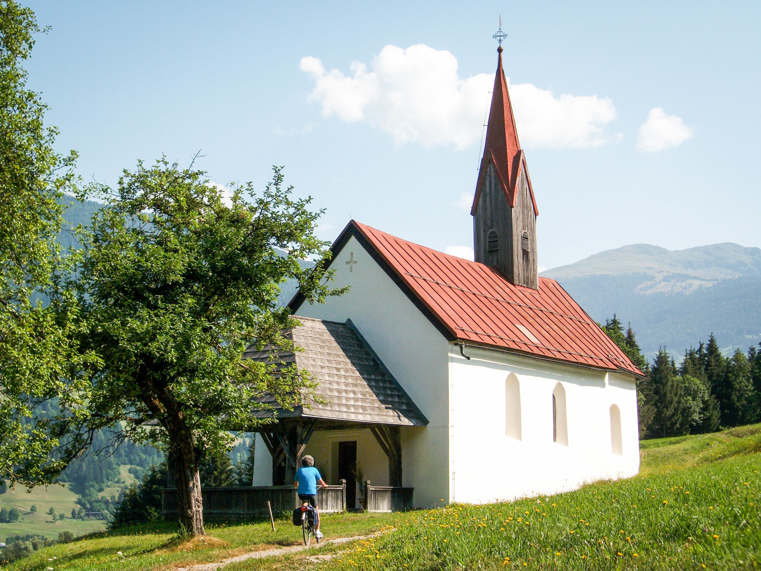 Cicloturista, percorso pianeggiante, paesaggio verde collinare, lungo ciclabile della Drava da Sillian a Villach, Austria