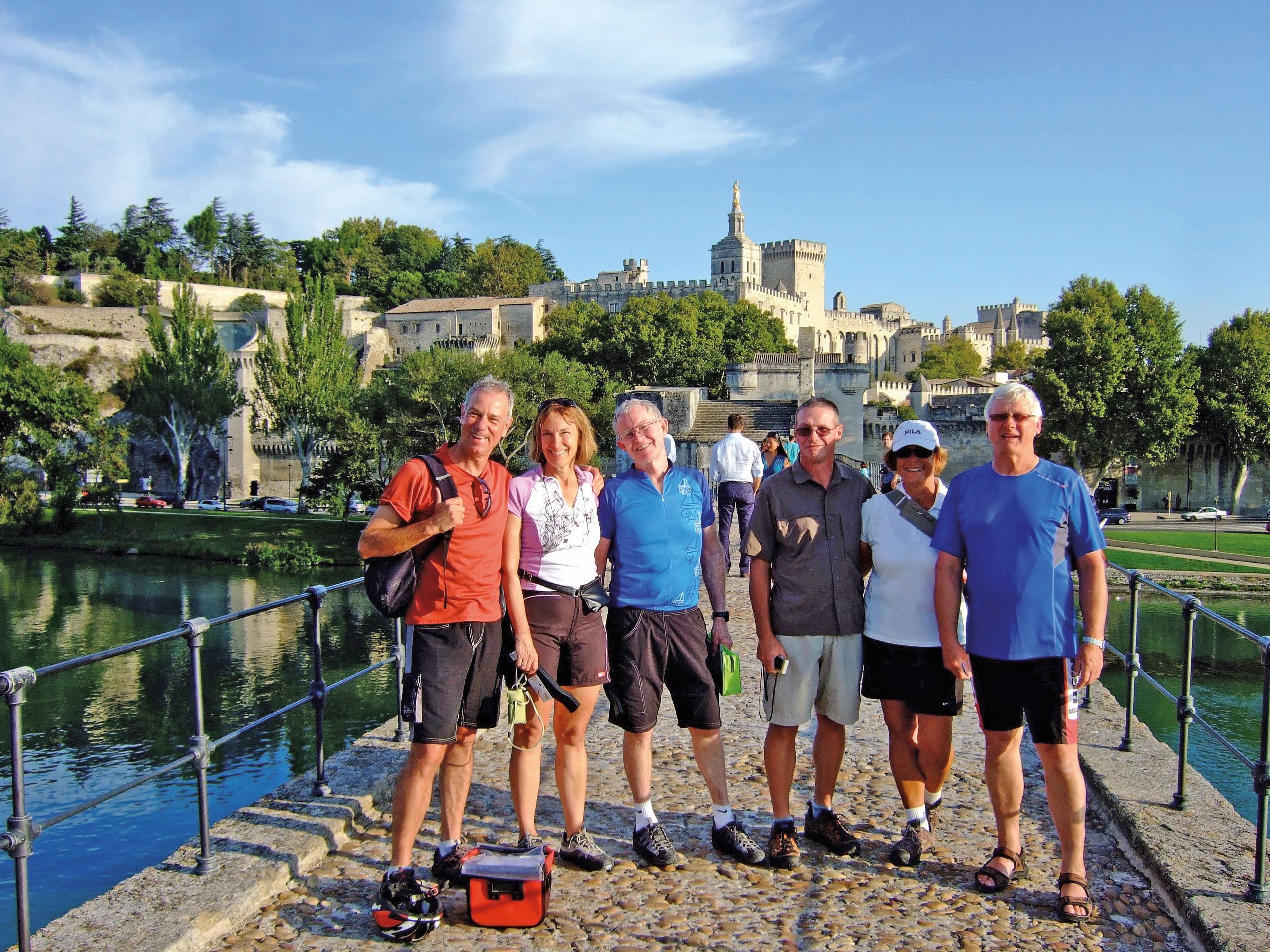 Group of cyclists posing on the Avignon bridge, Provence, France.