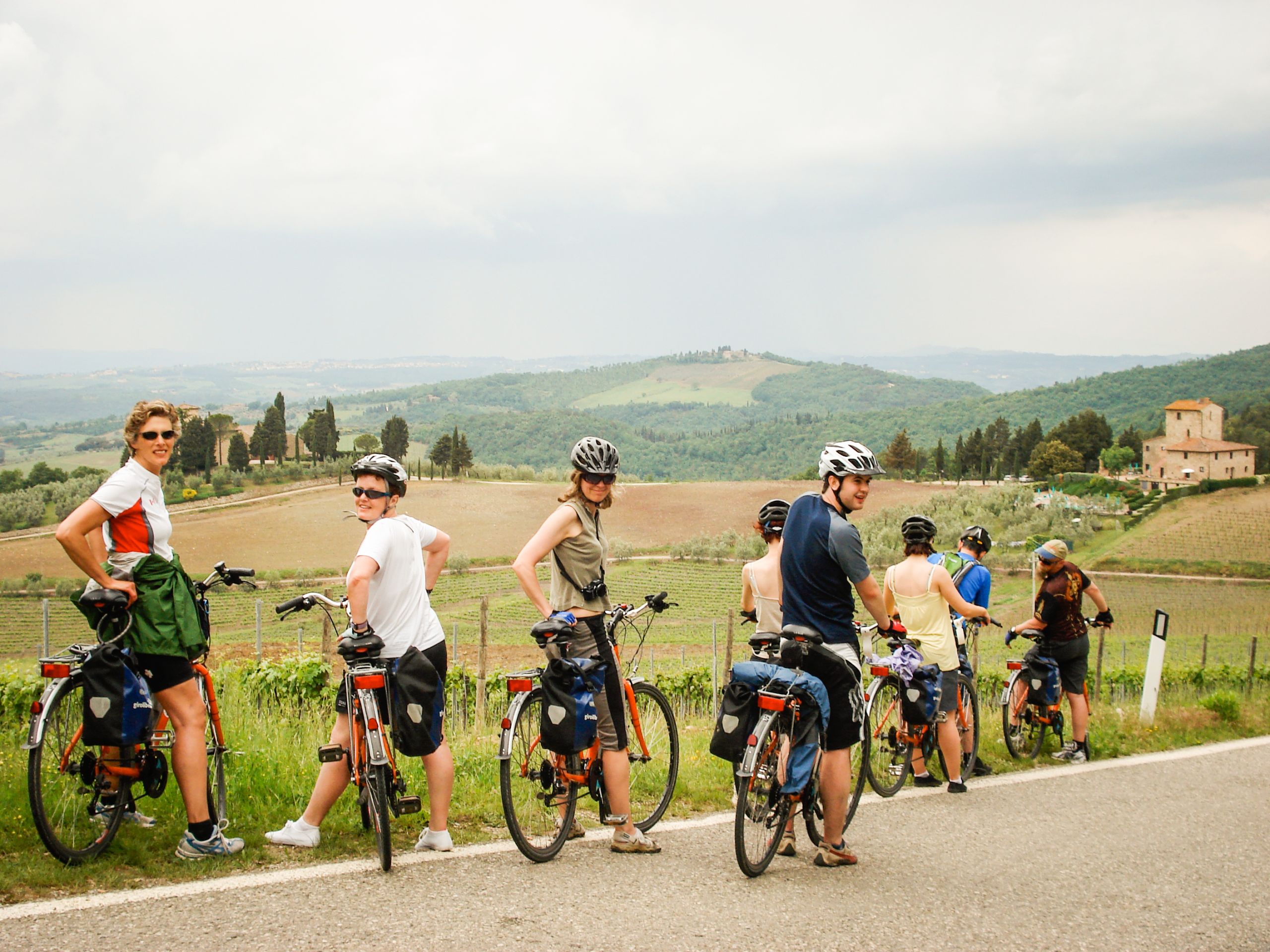 Gruppe von Radfahrern auf einer Landstraße mit Blick auf die Hügel der Toskana