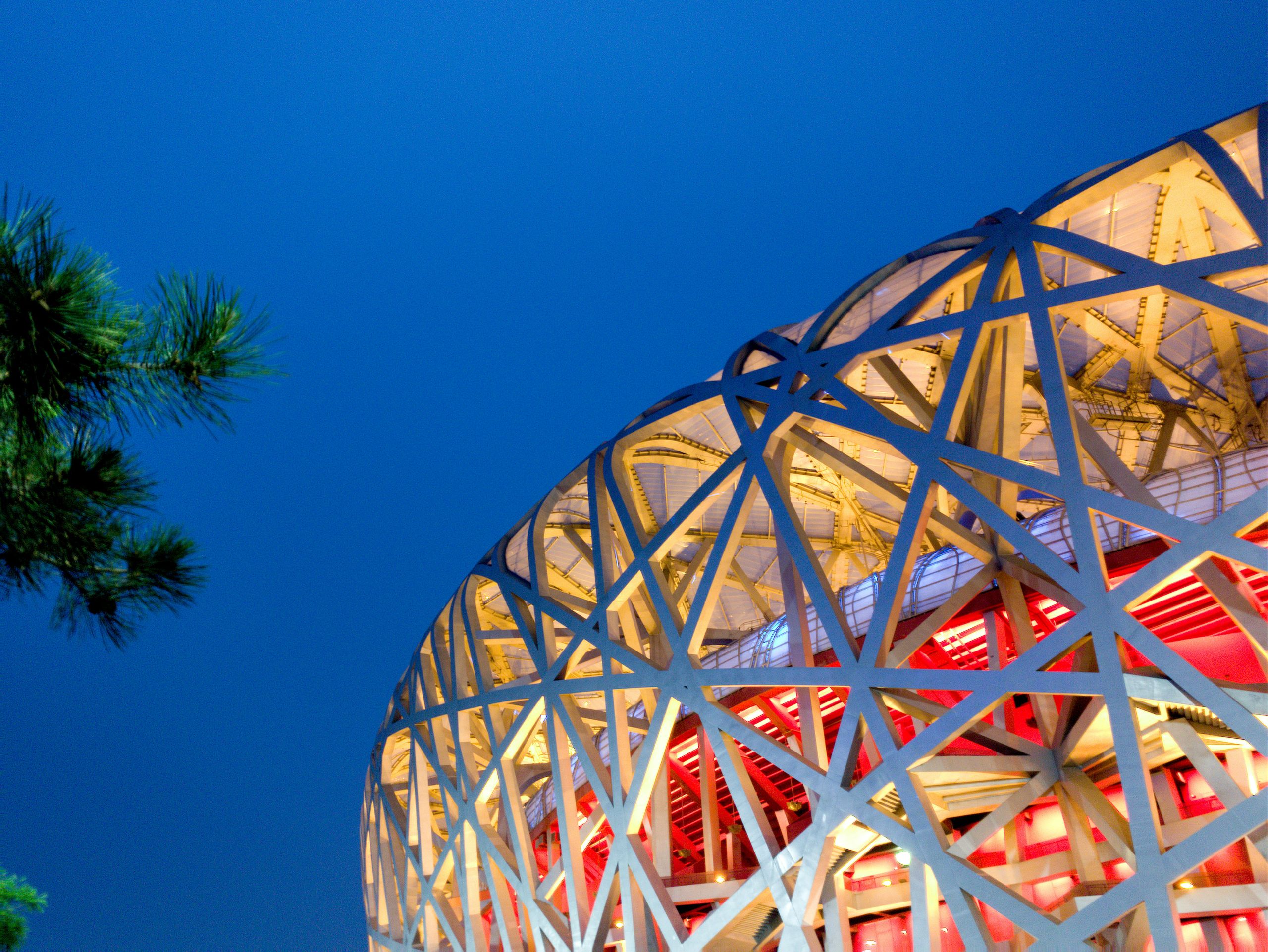 Vista del moderno Stadio Nazionale di Pechino, detto "Nido d'uccello", con cielo limpido.
