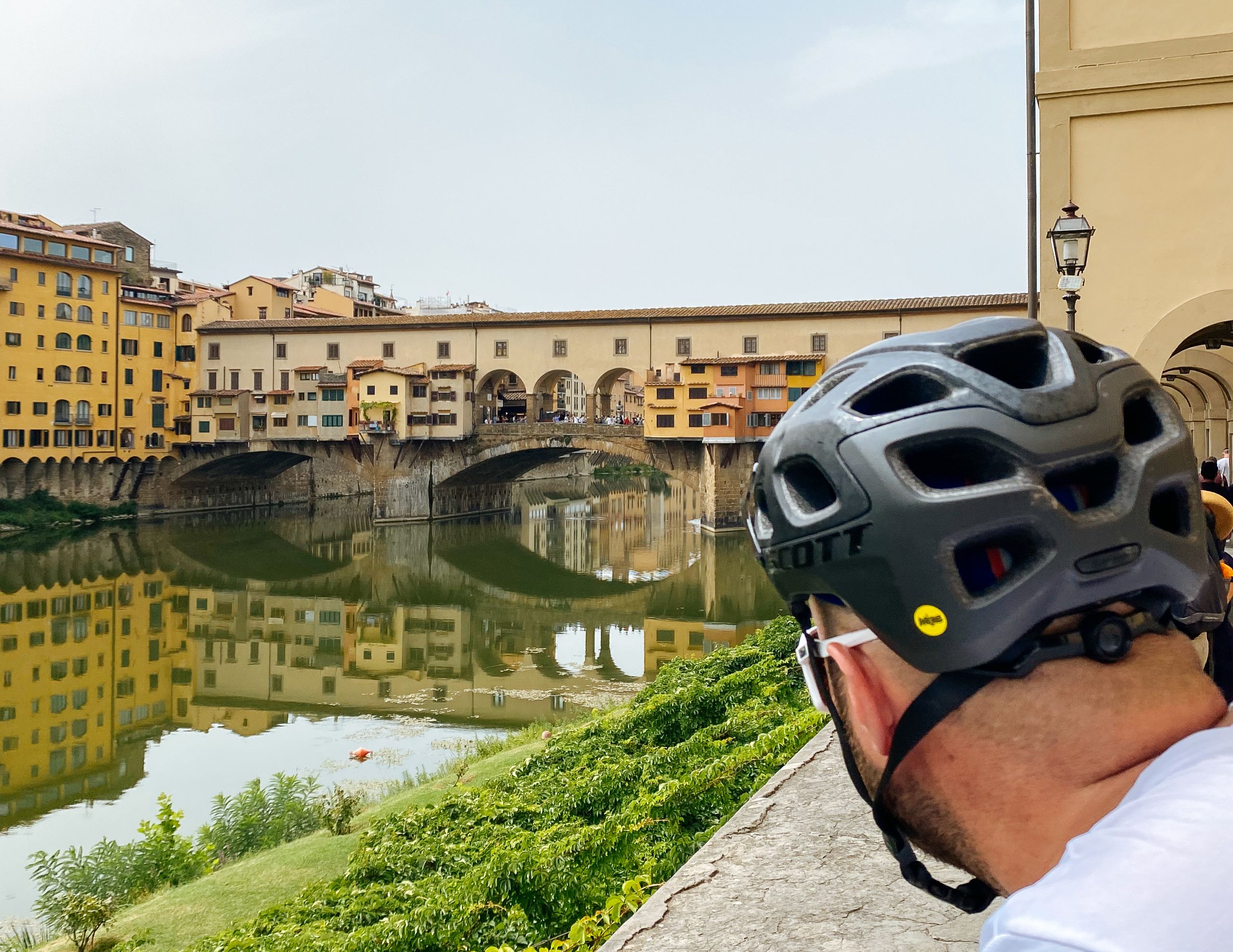 Cyclist admiring Ponte Vecchio in Florence, Italy.