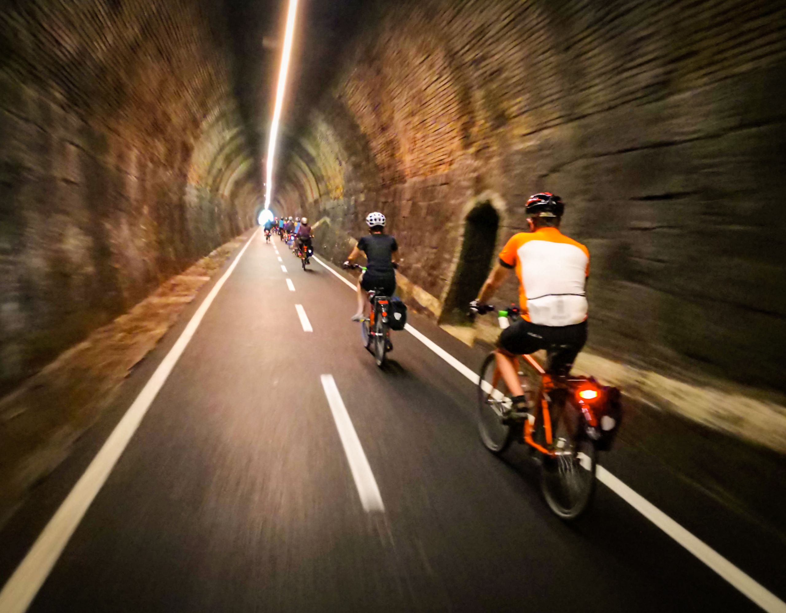 Biciclette che percorrono un tunnel ciclabile illuminato lungo la Ciclovia dell'Alpe Adria, Austria.