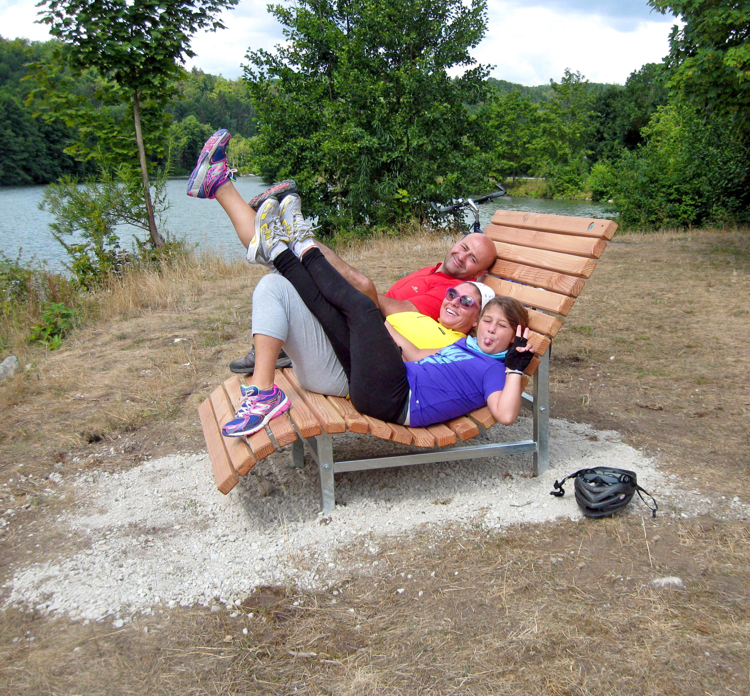 Famiglia che si rilassa su una panchina panoramica in legno nella natura, Germania del sud.