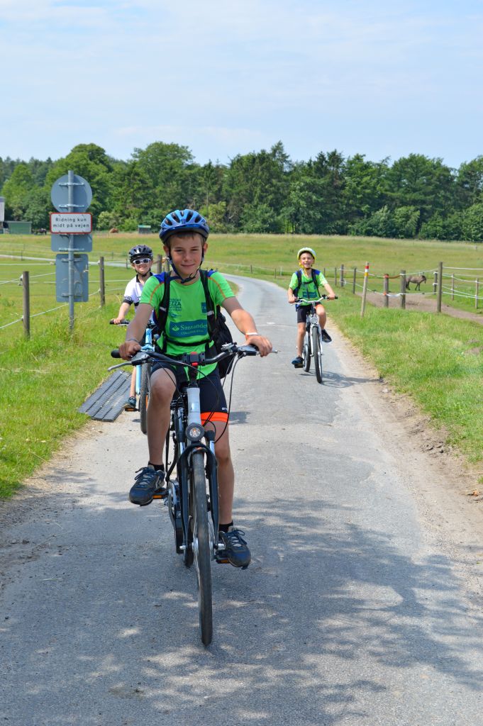 Bambini in bicicletta lungo un percorso ciclabile tra il verde in Danimarca