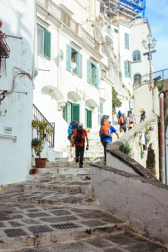 Turisti che camminano in un vicolo in pietra caratteristico ad Amalfi, Italia
