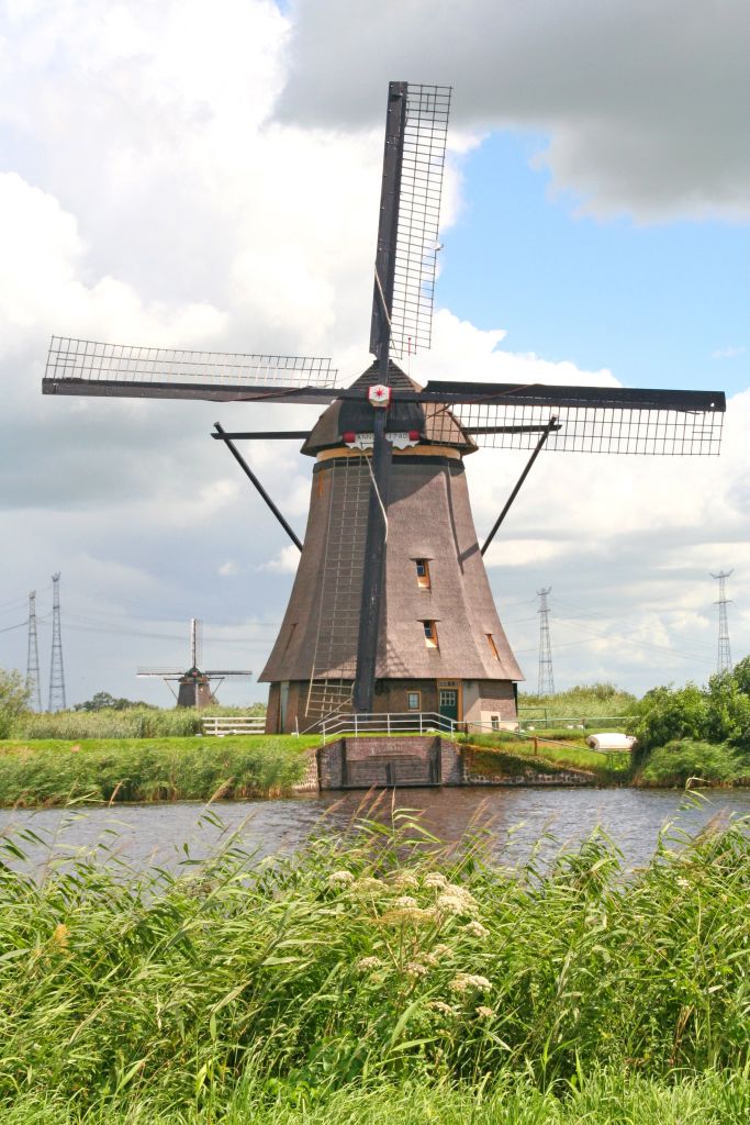Mulino a vento storico circondato da prati e corsi d'acqua vicino a Kinderdijk.