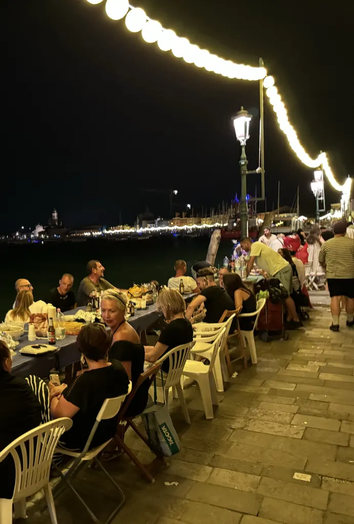 Cena all’aperto sul lungomare illuminato a Venezia in occasione della Festa del Redentore
