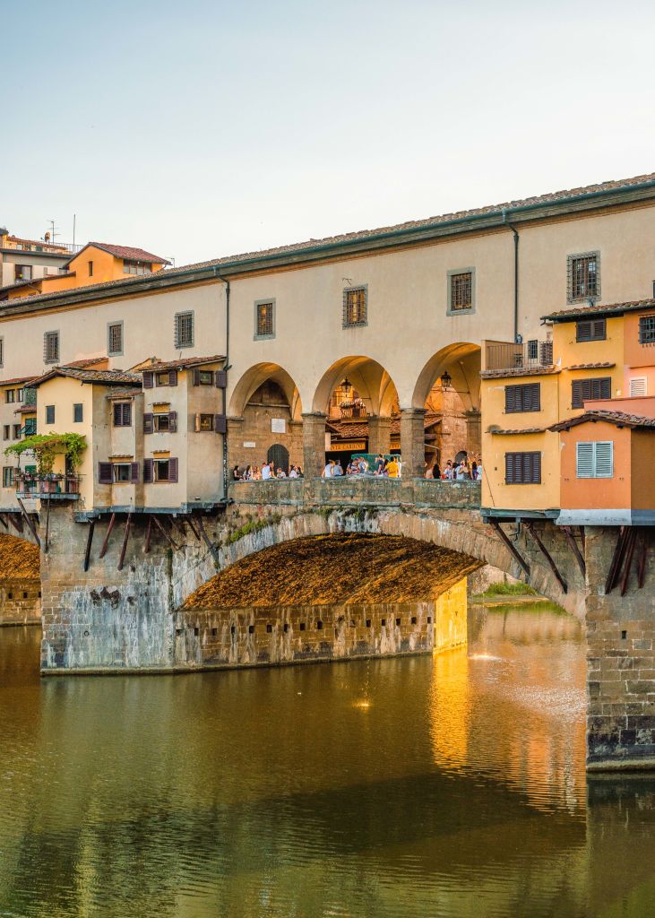 Visuale laterale su Ponte Vecchio, case in rilievo, fiume Arno, vacanza in bici all'aria aperta, Firenze, Toscana