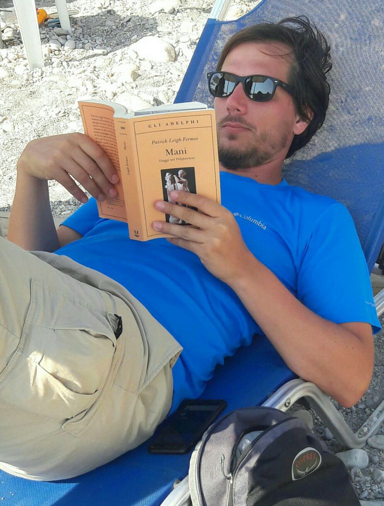 Guida escursionistica intenta a leggere un libro per preparare un trekking in natura