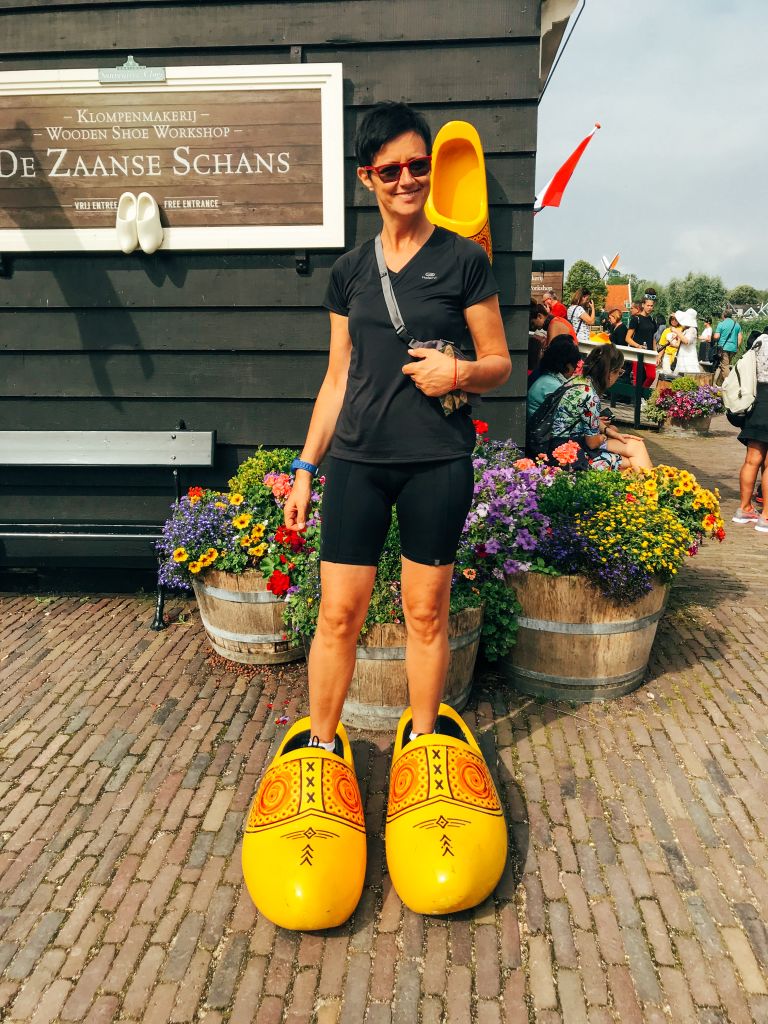 Turisti con zoccoli giganti in legno davanti a un negozio ad Amsterdam, Paesi Bassi.