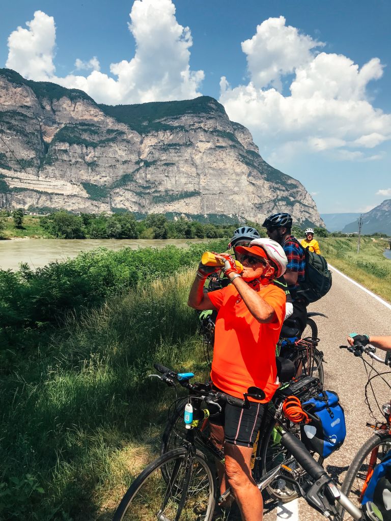 Gruppe von Radfahrern mit Blick auf Weinberge und Berge bei Rovereto, Italien.
