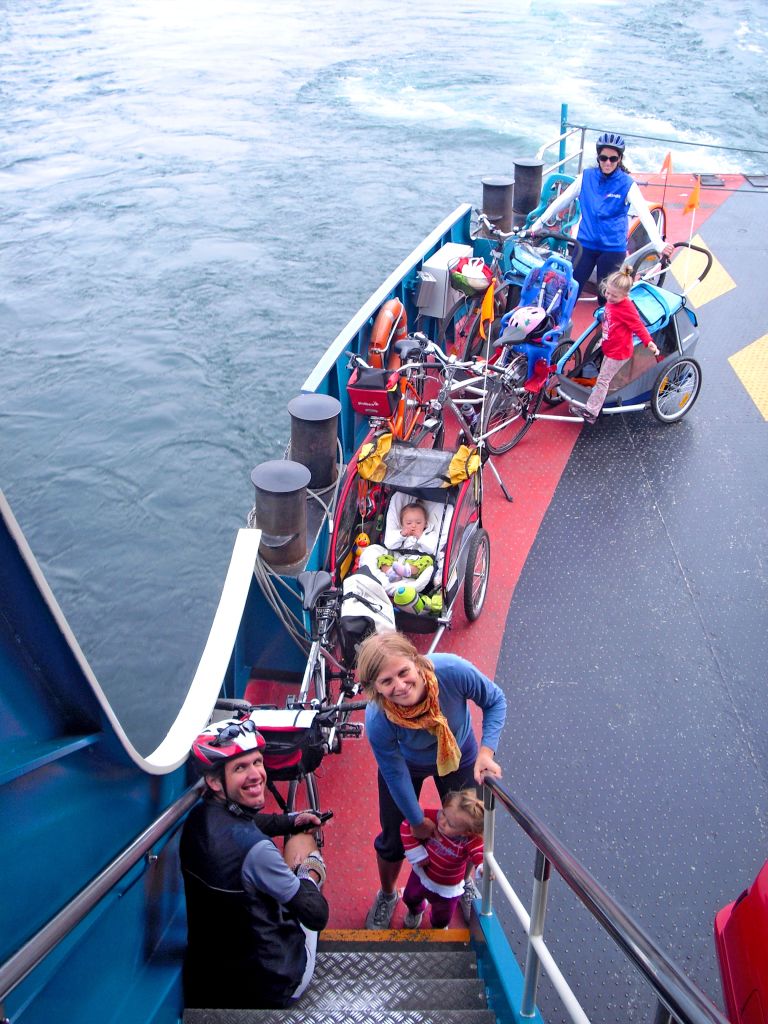 Ciclo escursionisti su un traghetto che attraversa il lago con bici a bordo.