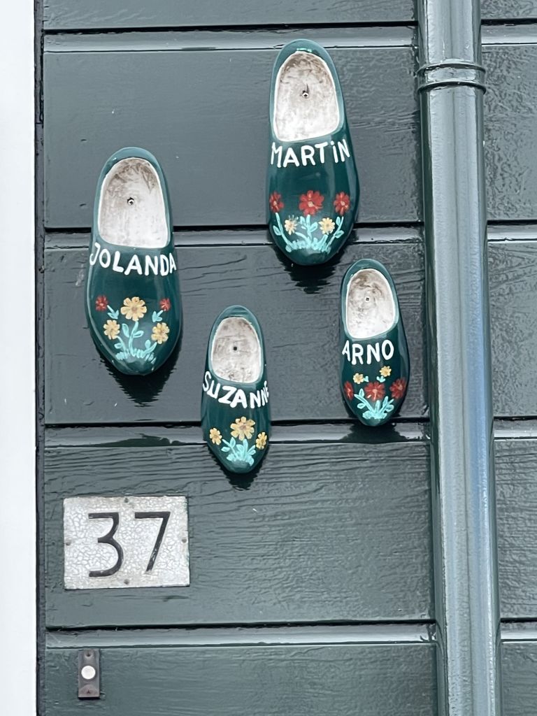 Numero civico decorato con zoccoli olandesi appesi al muro, Paesi Bassi.