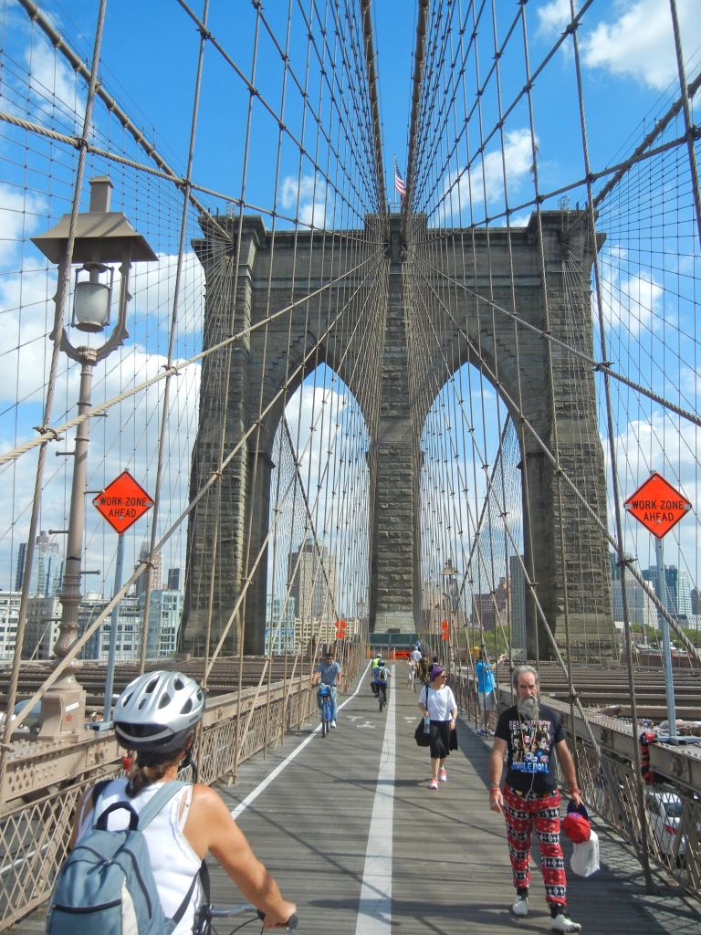 Ciclisti che attraversano in bicicletta il ponte di Brooklyn.