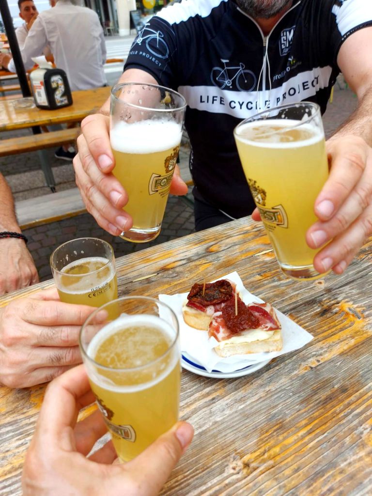 Ciclisti durante una pausa che brindano con birra