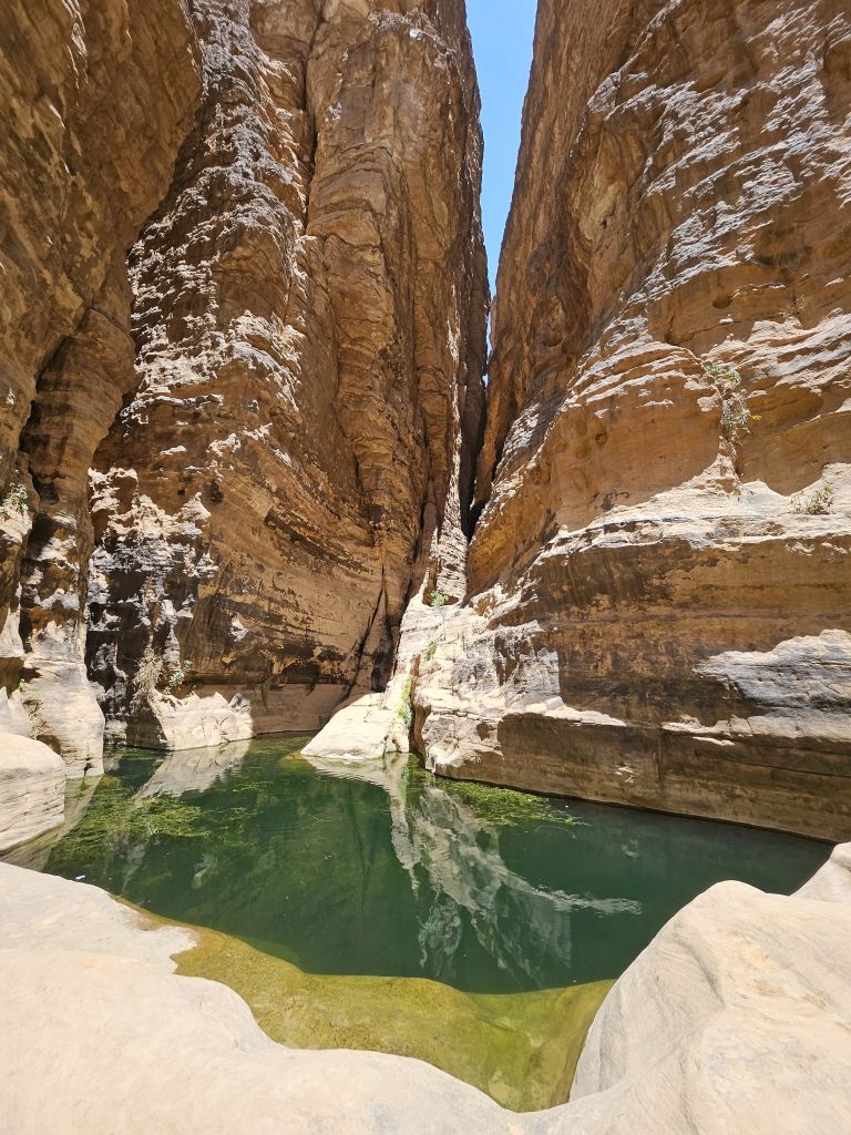 Stretta gola con pareti rocciose e piscina naturale d’acqua verde smeraldo, Algeria.