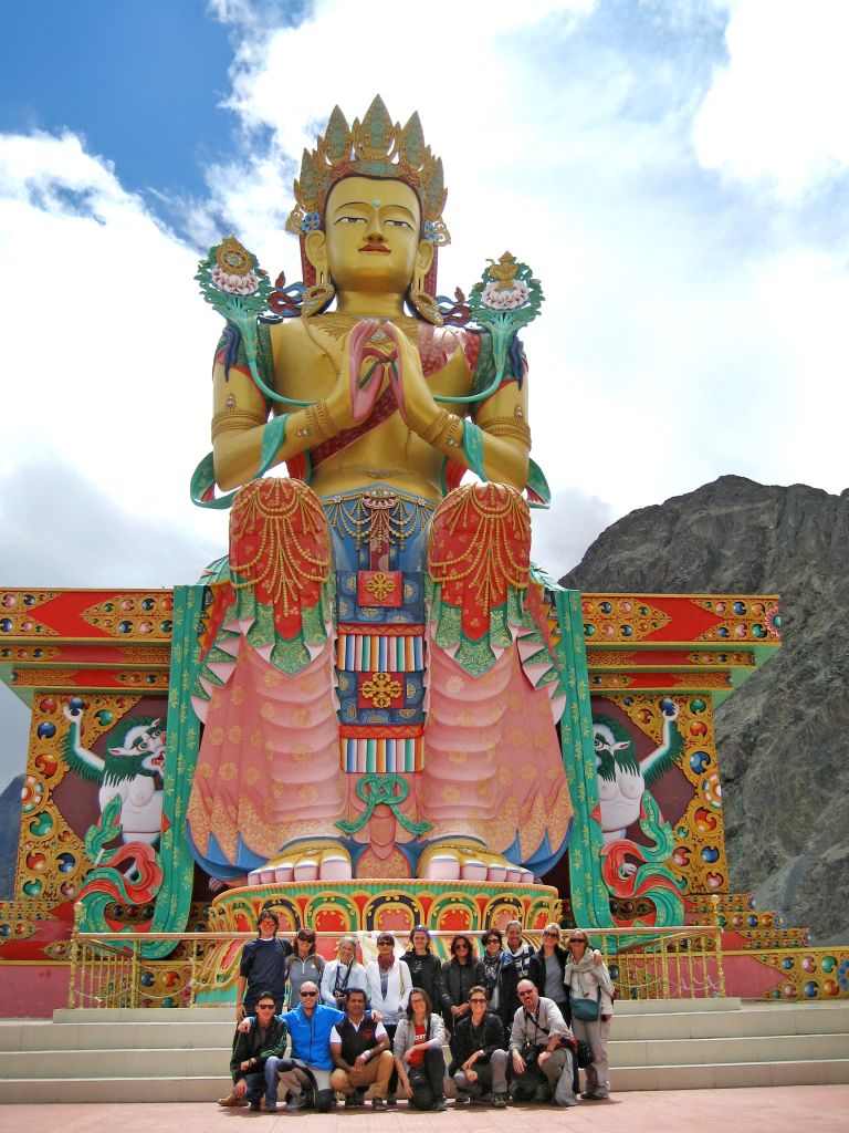 Statua dorata di Maitreya Buddha a Diskit, nella valle di Nubra, con gruppo di turisti alla base.
