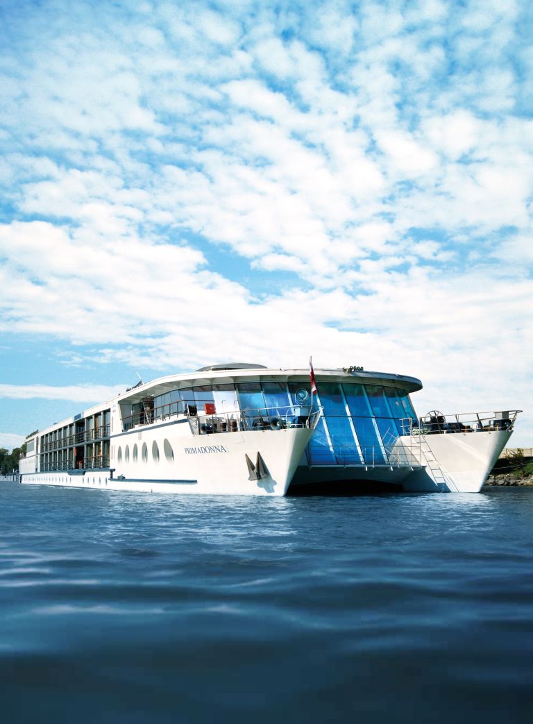 Catamarano bianco "Primadonna" che naviga lungo un fiume in una bella giornata