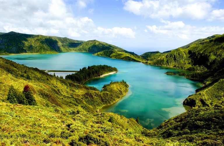 Escursionisti vicino a un lago panoramico circondato dal verde nell'Isola di San Miguel, Azzorre.