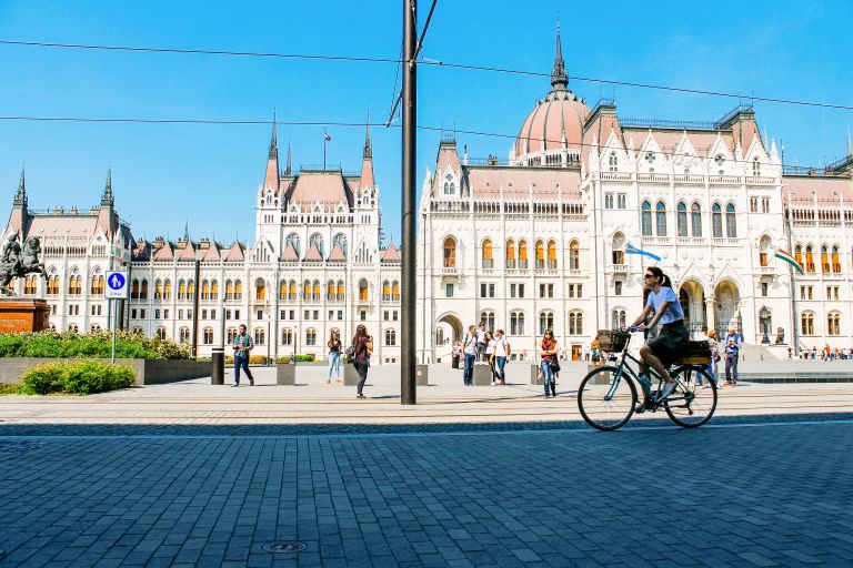 Cyclist passes in the center of Budapest passes in front of the Parliament