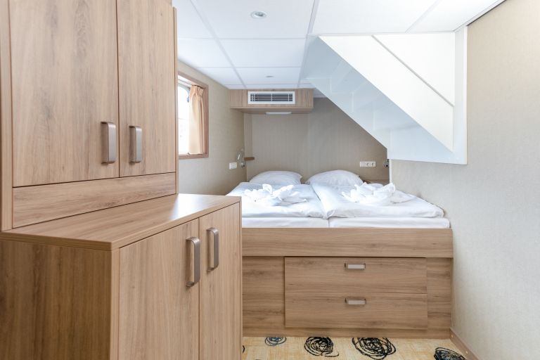 Cabina matrimoniale con armadio e finestra