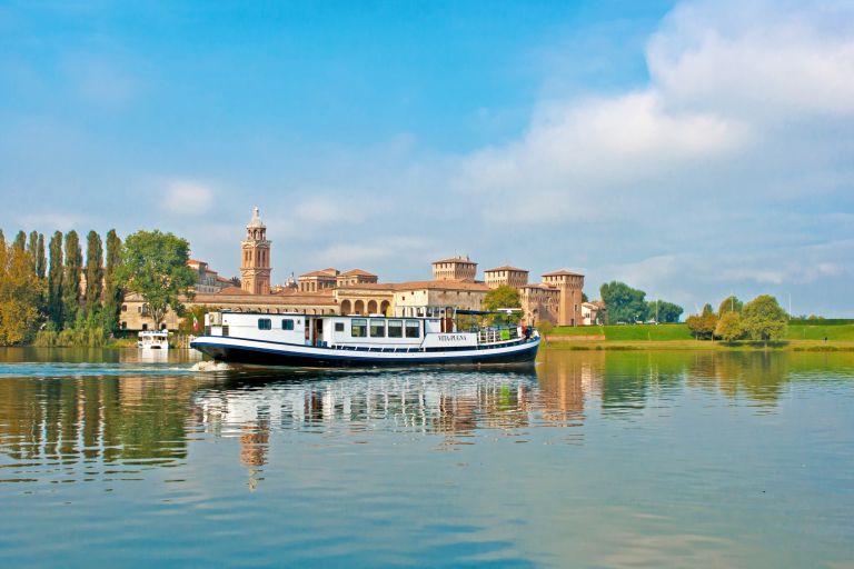 Barca "Vita Pugna" sul fiume Mincio con la vista del Castello di San Giorgio a Mantova, Italia.