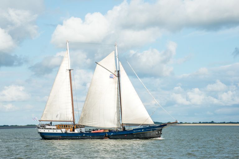 Barca a vela che naviga nel Mare del Nord con cielo nuvoloso, Olanda.