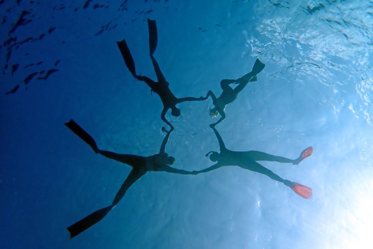 Snorkeling subacqueo con quattro persone che nuotano nel mare delle Maldive