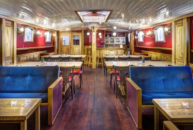 Salotto interno con divani blu e decorazioni in legno lucido.