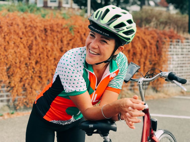 Guida sorridente appoggiata alla bicicletta