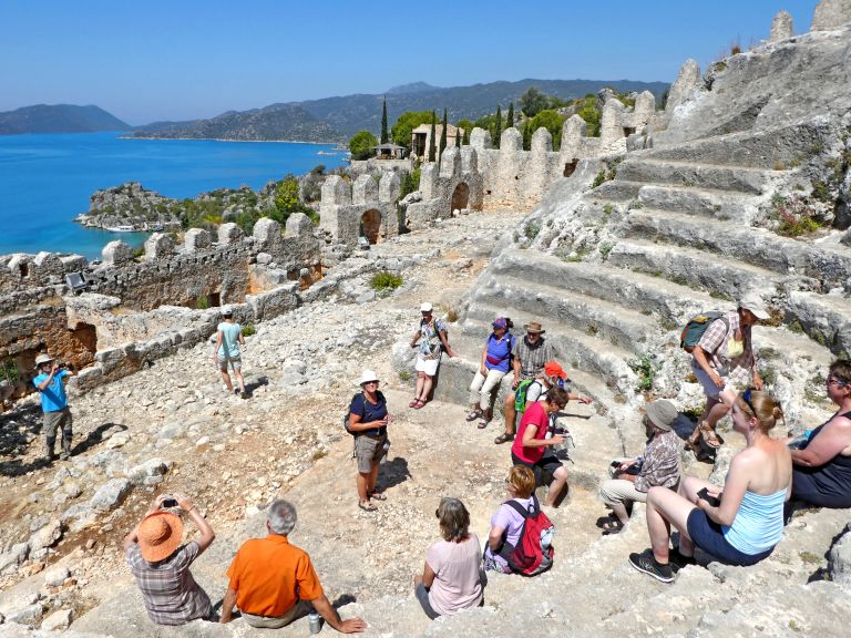 Turisti tra le rovine di un antico teatro con vista sul mare, Turchia