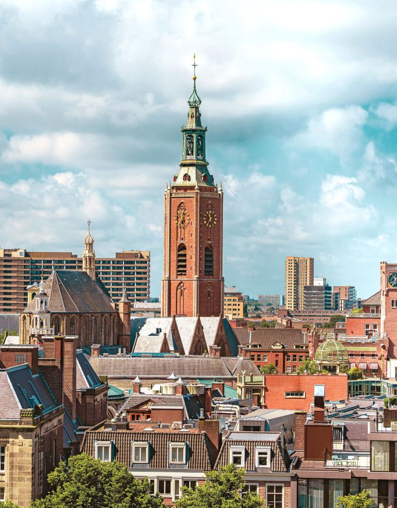Vista panoramica del centro storico de L'Aia con la Torre della Chiesa Grande (Grote Kerk) e il cielo azzurro.