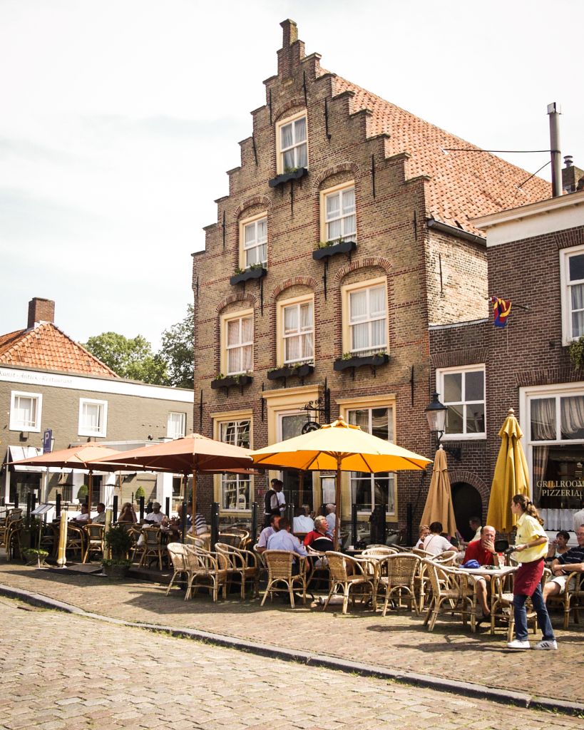 Caffè all'aperto in una piazza di Maastricht con edifici in stile olandese