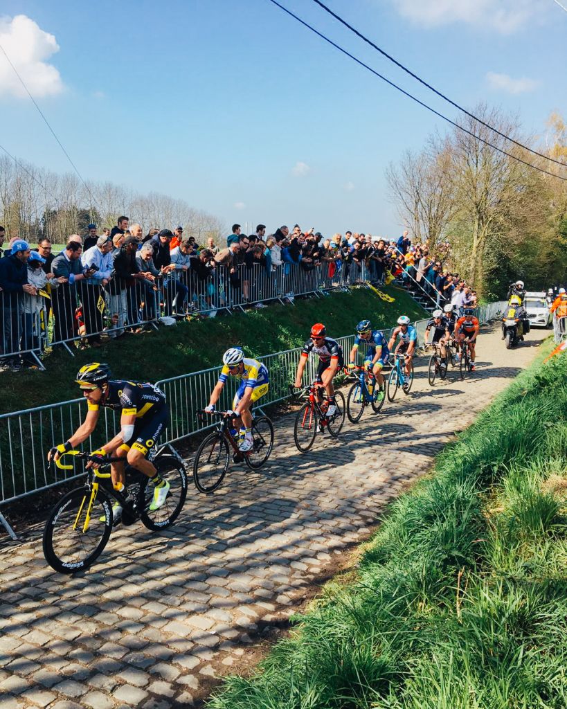 Ciclisti impegnati su un tratto di pavé durante una gara ciclistica nelle Fiandre