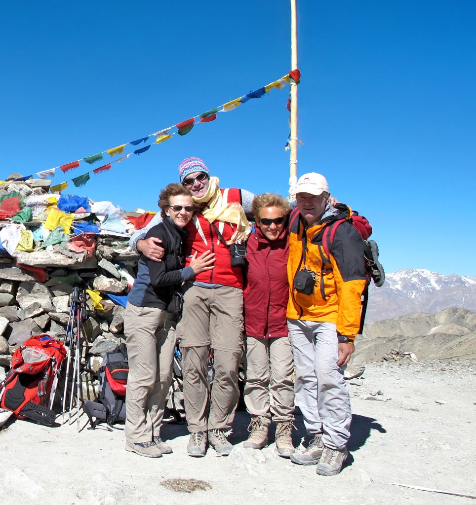 Escursionisti al passo Khardung La con bandiere di preghiera tibetane, nei pressi di Leh, Ladakh.