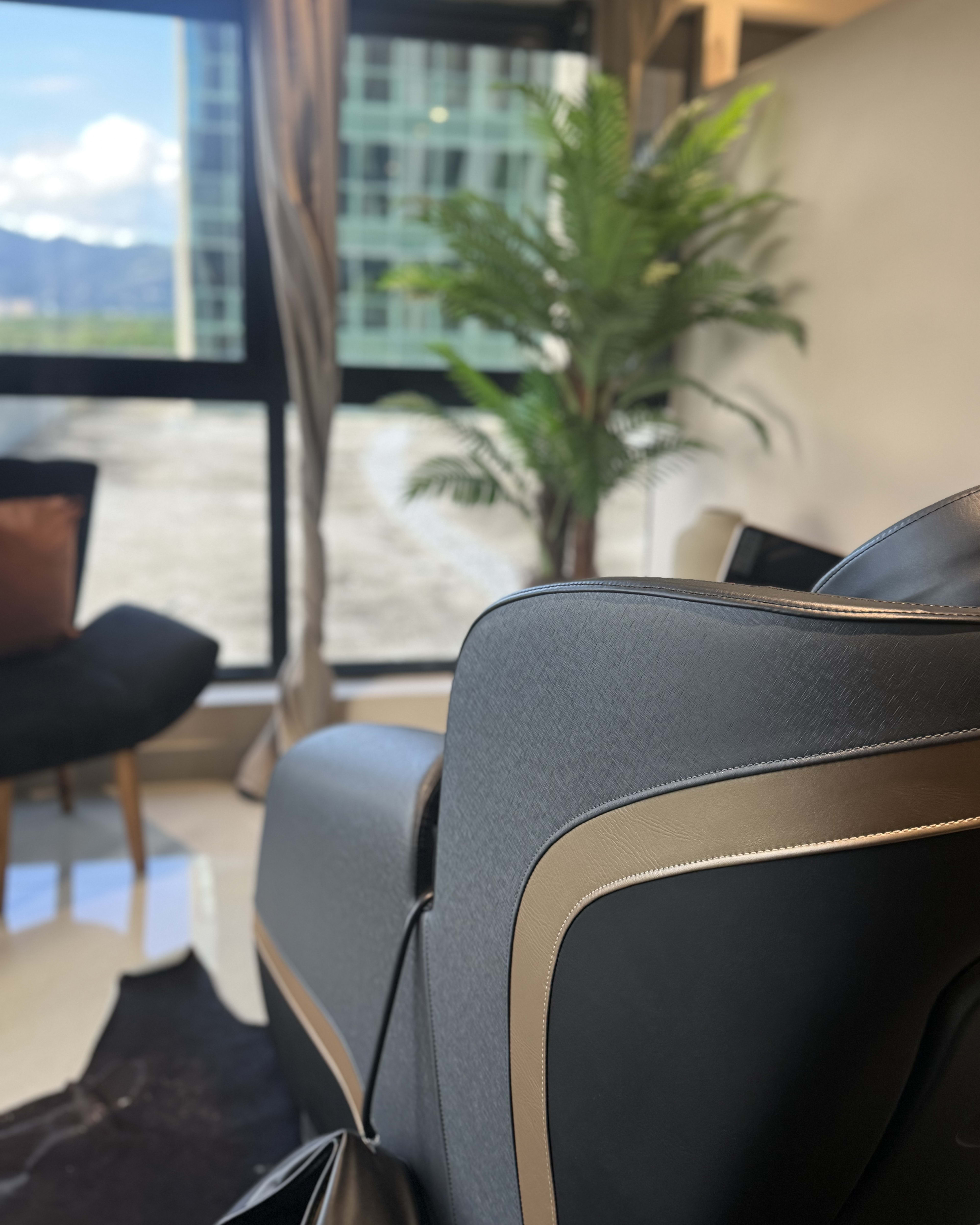 Sala de atendimento da clínica com poltrona, planta e janela ampla com vista para a cidade