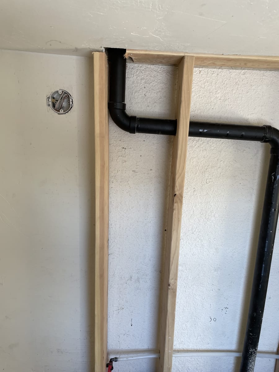 framing around added pipes outside a main wall