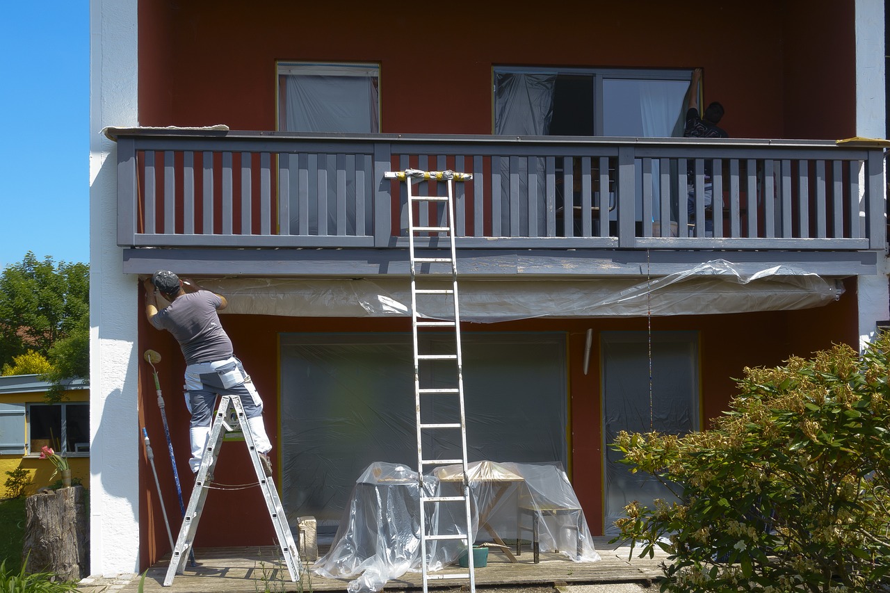 man painting exterior of a home