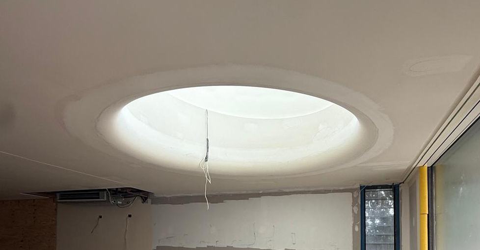 Ceiling level change defining living zone while maintaining open circulation