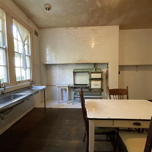Original kitchen showing tiled recess, stove and sink