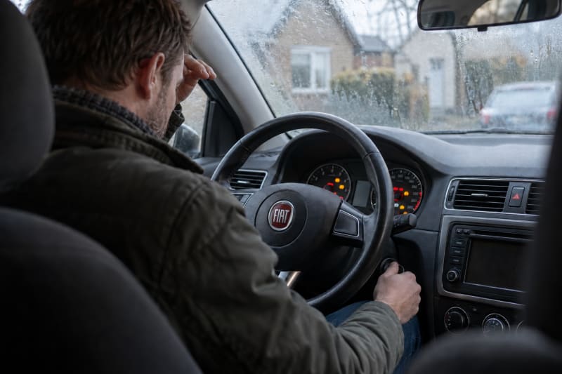 Bestuurder in auto die niet start door accupech of storing