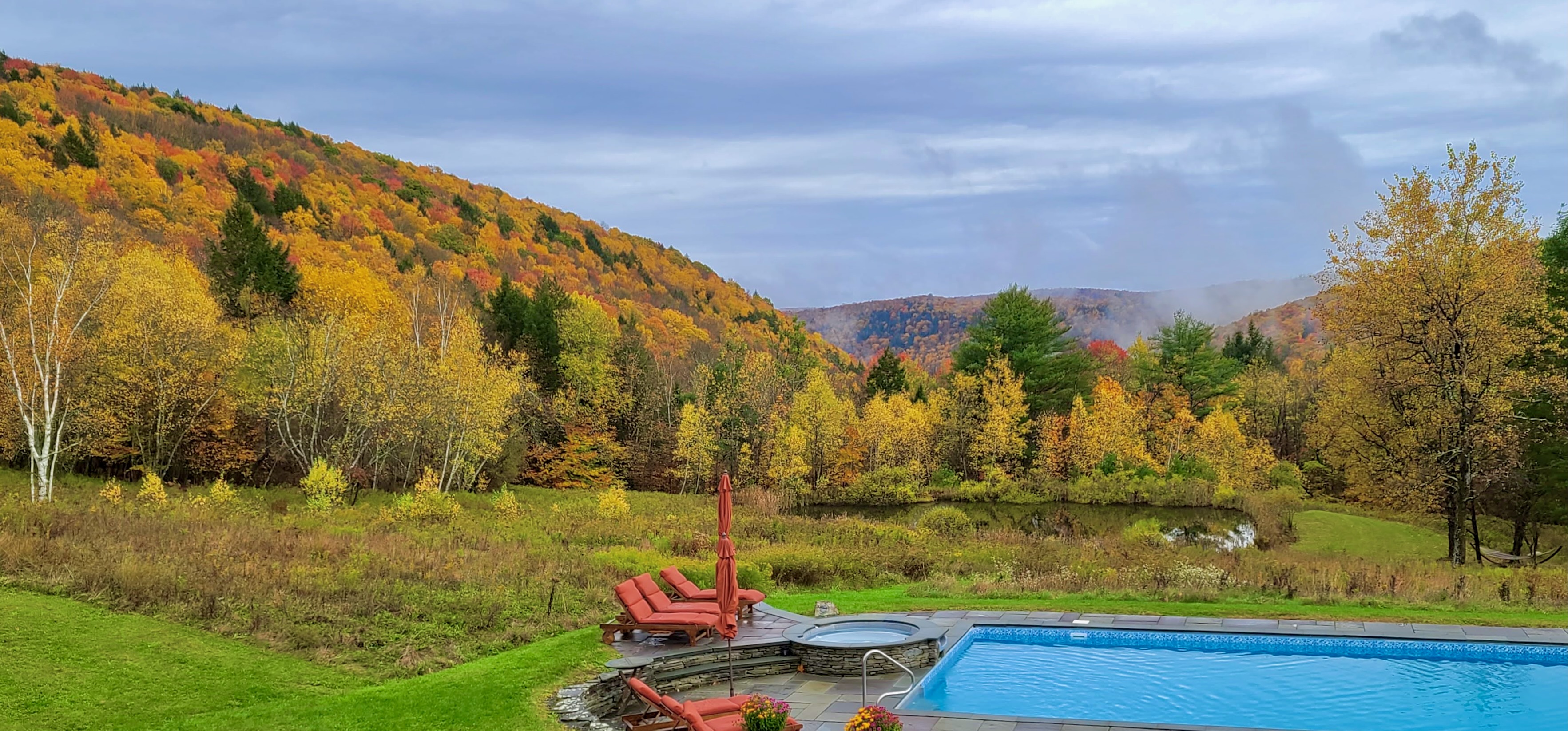 Heated pool with fall foliage Catskills mountain backdrop at Mountain Meadows private resort Long Eddy NY