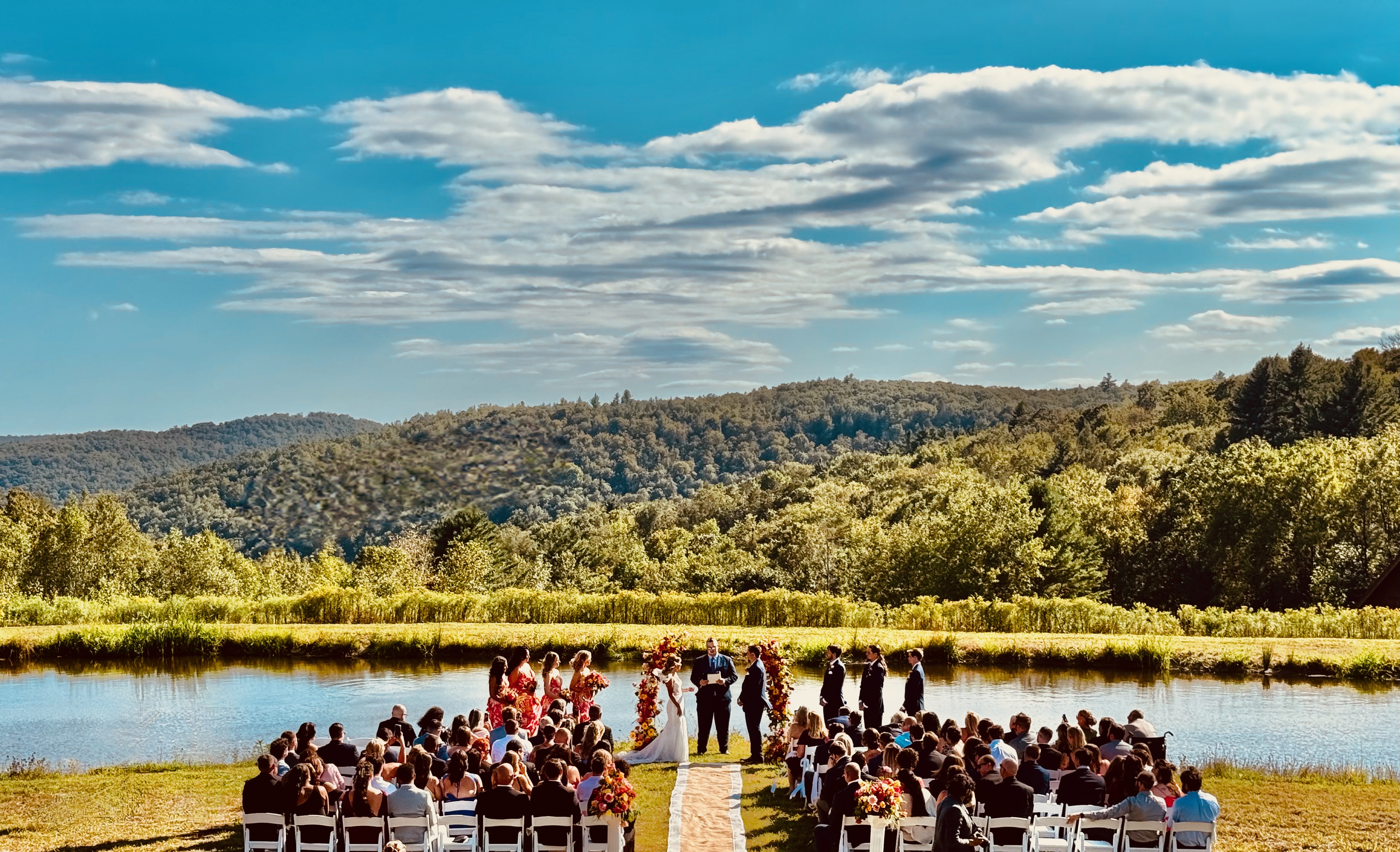 Outdoor wedding ceremony by the pond with Catskills mountain views at Mountain Meadows private wedding venue Long Eddy NY